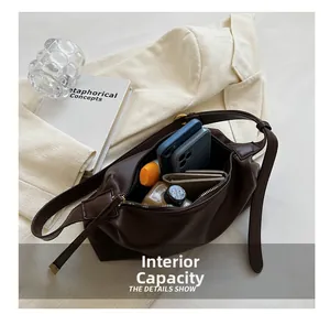 Gros plan sur l'intérieur spacieux du sac cabas en cuir marron avec des objets du quotidien