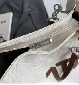 Détail du sac cabas blanc plissé avec fermeture éclair métallique fluide et anse en cuir