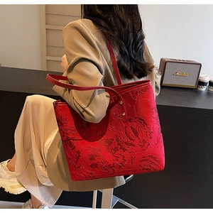 Detailed view of red floral jacquard tote bag featuring vintage embossed fabric patterns