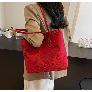 Detail of red tote bag featuring exquisite 3D floral jacquard pattern and long straps