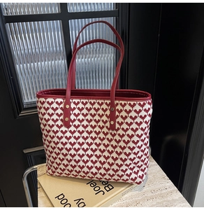 Detail of red pixel heart tote bag showing leather handles and gold metal rivets