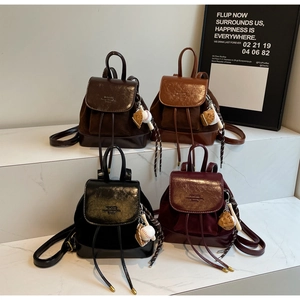 Detail of four colorful mini backpacks with metal buckles, drawstring, and baseball charms