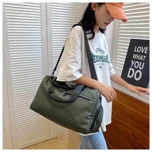 Detail of dark green waterproof sports bag featuring durable nylon fabric and woven handles