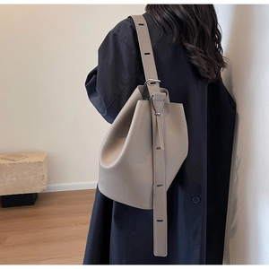 Detail view of grey lychee grain leather bucket bag with adjustable shoulder strap