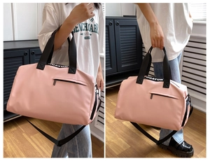 Detail of pink sports bag showing the reinforced black straps and white logo lettering
