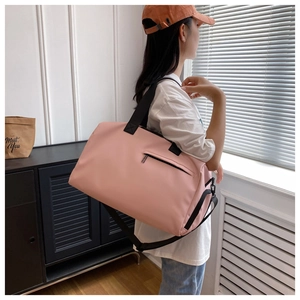 Detail view of the pink gym bag showing adjustable strap and front zipper pocket