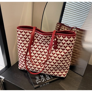 Macro detail of red and white woven pattern on large tote bag with leather rivet handles