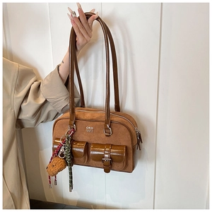 Detail of vintage brown bowling bag with suede finish and cute bear plush charm