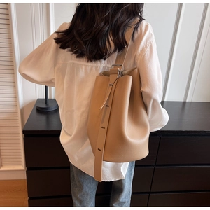 Detailed back view of khaki minimalist bucket bag with adjustable strap and pebble texture