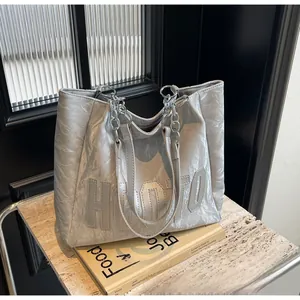 Détail du sac cabas plissé gris argenté avec logo HOTO embossé et anse chaîne argentée