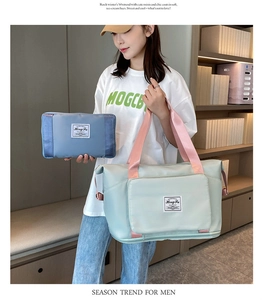 Detail view of mint green Oxford cloth travel bag with pink handles and matching pouch