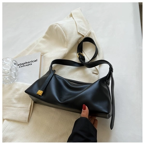 Détail du sac cabas en cuir noir mat avec bandoulière réglable et logo embossé