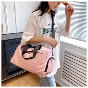 Pink waterproof fitness bag with wet-dry separation shown on shoulder in lifestyle setting