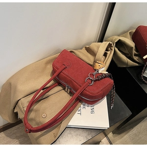 Close-up of red canvas handbag with white stitching and decorative woven rope detail
