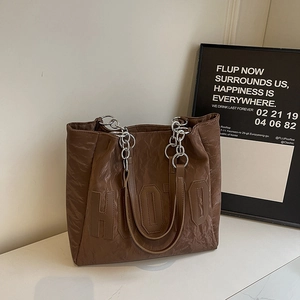 Détail du grand sac cabas marron foncé avec logo HOJO et bandoulière en chaîne