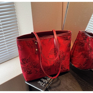 Detailed view of the red rose jacquard texture on a large wedding tote bag with leather handles