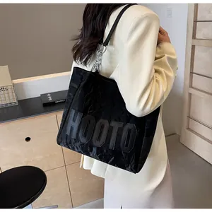 Vue latérale d'un grand sac fourre-tout HOOTO noir avec chaîne argentée et cuir