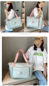 Detail of mint green oxford travel bag with pink handles and waterproof bottom compartment