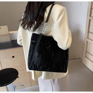 Détail d'un sac cabas noir avec écusson HOOTO et bandoulière en chaîne argentée
