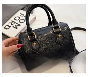 Macro view of the black Boston bag back with pleated leather texture and gold hardware