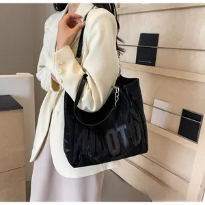 Détail du sac cabas noir avec lettres HUOTO en relief et chaîne en argent chic