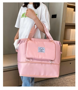 Pink Oxford travel bag with bottom shoe compartment shown in an indoor lifestyle setting