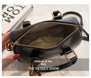 Interior view of black pleated leather Boston bag with beige lining and gold zipper