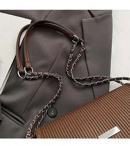 Détail du cabas plissé marron avec bandoulière chaîne argentée et garniture métal
