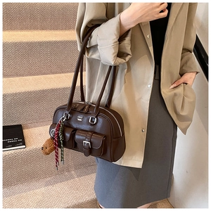Detail of vintage coffee shoulder bag with dual exterior buckle pockets and twin handles