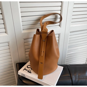Detail of premium brown pebble leather bucket bag with silver buckle and adjustable strap