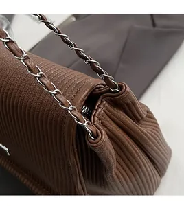 Vue détaillée de la texture en cuir plissé marron foncé et de la chaîne argentée