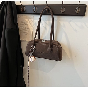 Detail of brown suede Boston bag featuring embossed logo and silver dual zipper closure