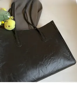 Detail showing the retro crinkled texture of black faux leather on the large tote bag