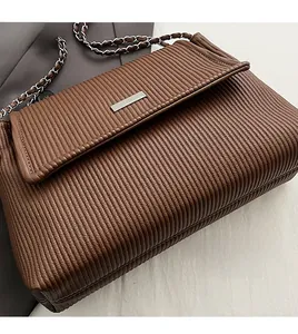 Détail du fermoir en métal argenté et de la texture en cuir plissé du sac cabas marron