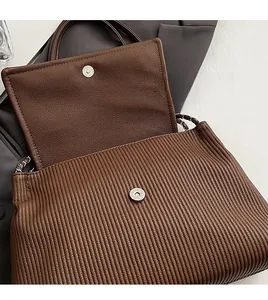 Détail du cabas en cuir marron foncé avec plis et fermoir magnétique en métal argenté