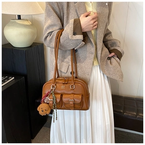 Brown retro bowling bag with double pockets and bear pendant shown on model