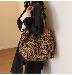 Detalle del bolso tote con estampado de leopardo, parche de cuero marrón y correas de lona