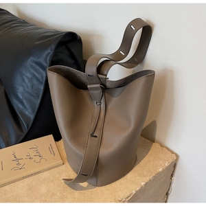 Detailed view of elephant gray lychee leather bucket bag with premium strap buckle