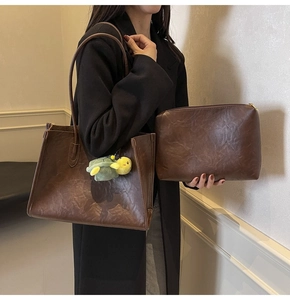 Detail of vintage brown leather tote bag set with turtle charm and matching pouch