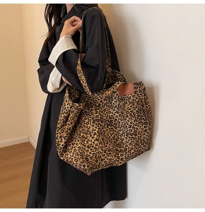Detalle del bolso tote con estampado de leopardo, etiqueta de cuero y tejido lona