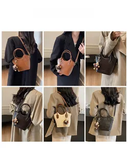 Modella che indossa la borsa a secchiello vintage con ciondolo a orsetto e tracolla