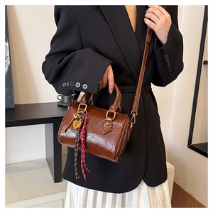 Detail of vintage brown Boston bag with golden heart lock and decorative braid