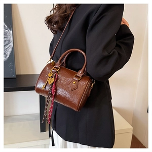 Brown vintage Boston bag with glossy texture, dual handles and heart charm decoration