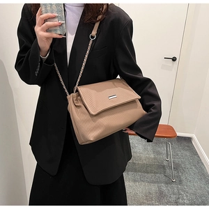 Détail du sac plissé kaki avec fermoir métallique rectangulaire et bandoulière en chaîne