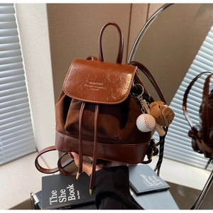 Detail of brown mini backpack with PU leather flap and suede body with baseball pendant