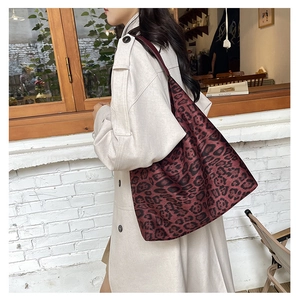 Detail view of the leopard print tote bag styled with a white trench coat on a model
