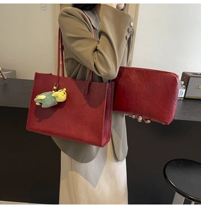 Detail of vintage dark red leather tote bag with small pouch and plush charm