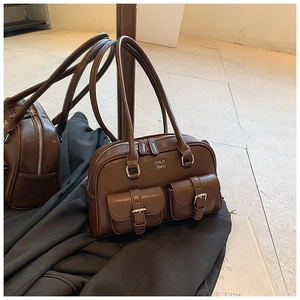 Detail of dark brown leather bowling bag with silver buckles and mirror reflection