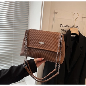 Détail du sac cabas en velours côtelé marron avec chaîne argentée et rabat aimanté