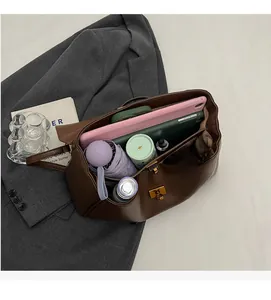 Detail view of the spacious interior of this brown leather tote bag with gold rotary clasp